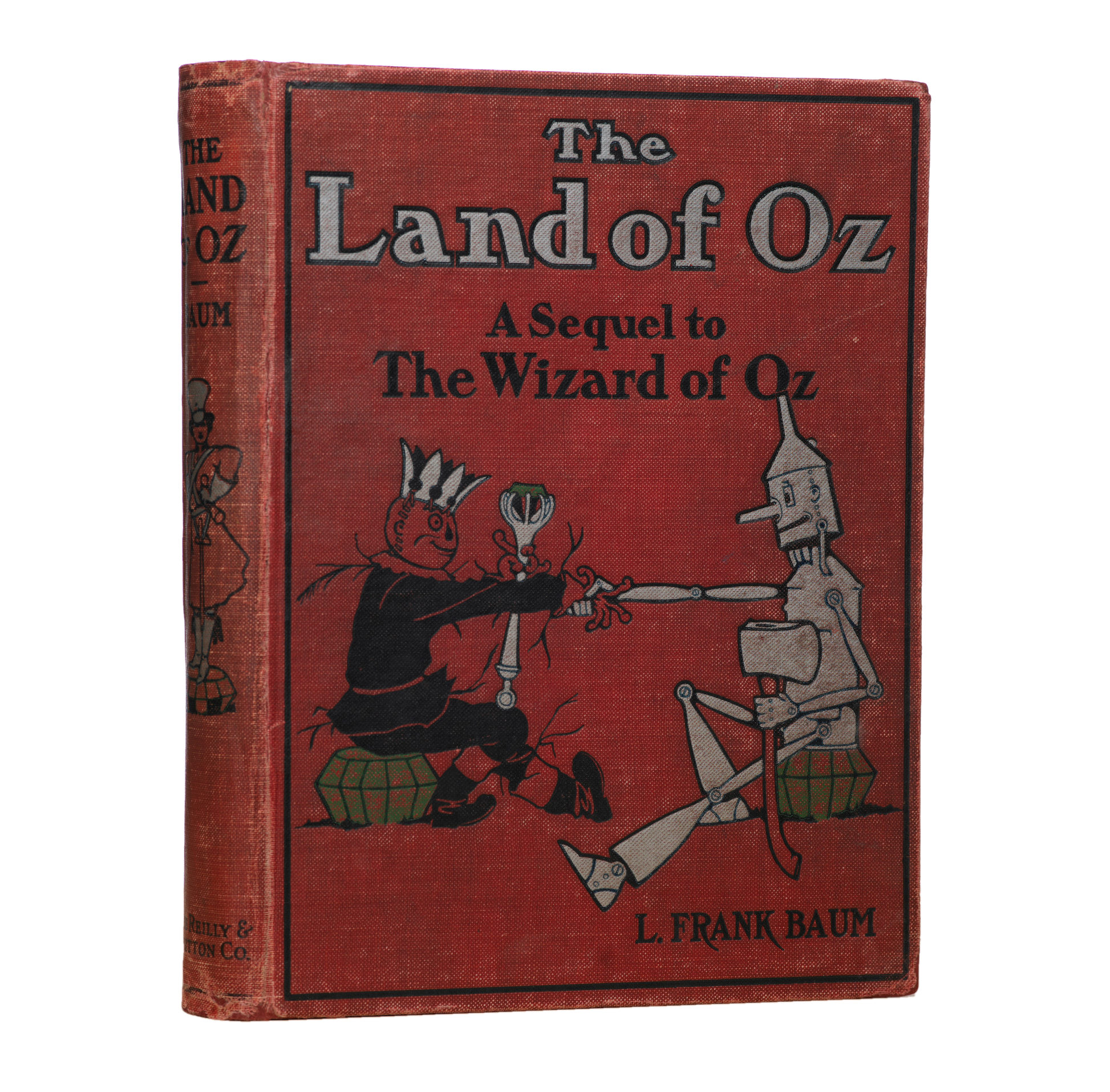 Front cover of a 1904 copy of The Land of Oz by L. Frank Baum, showing the worn red cloth binding and illustrated cover.